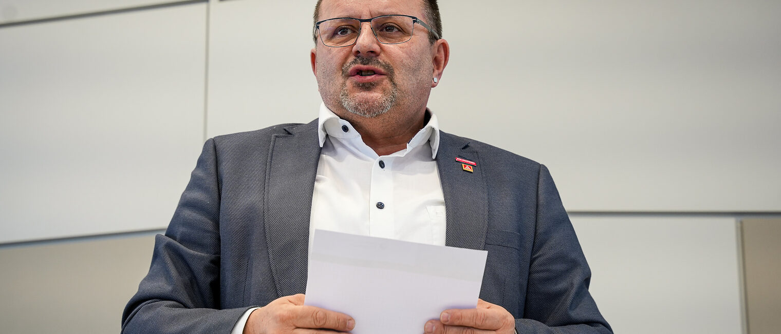 HWK-Vizepräsident Harald Sattler hält Unterlagen in der Hand und trägt seinen Standpunkt vor.