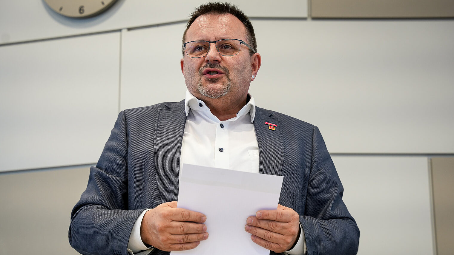 HWK-Vizepräsident Harald Sattler hält Unterlagen in der Hand und trägt seinen Standpunkt vor.