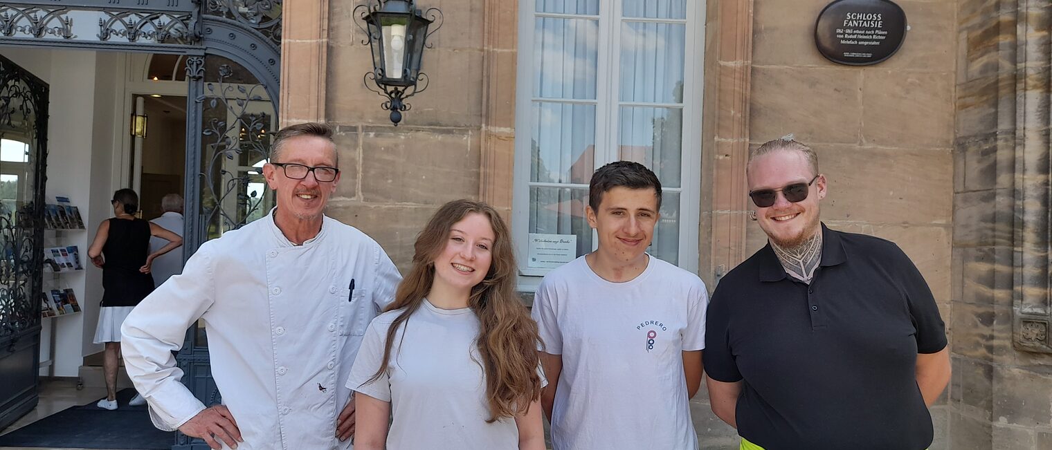 Französische Azubis und Ausbildungsbegleiter posieren vor dem Schloss Fantaisie in Bayreuth.