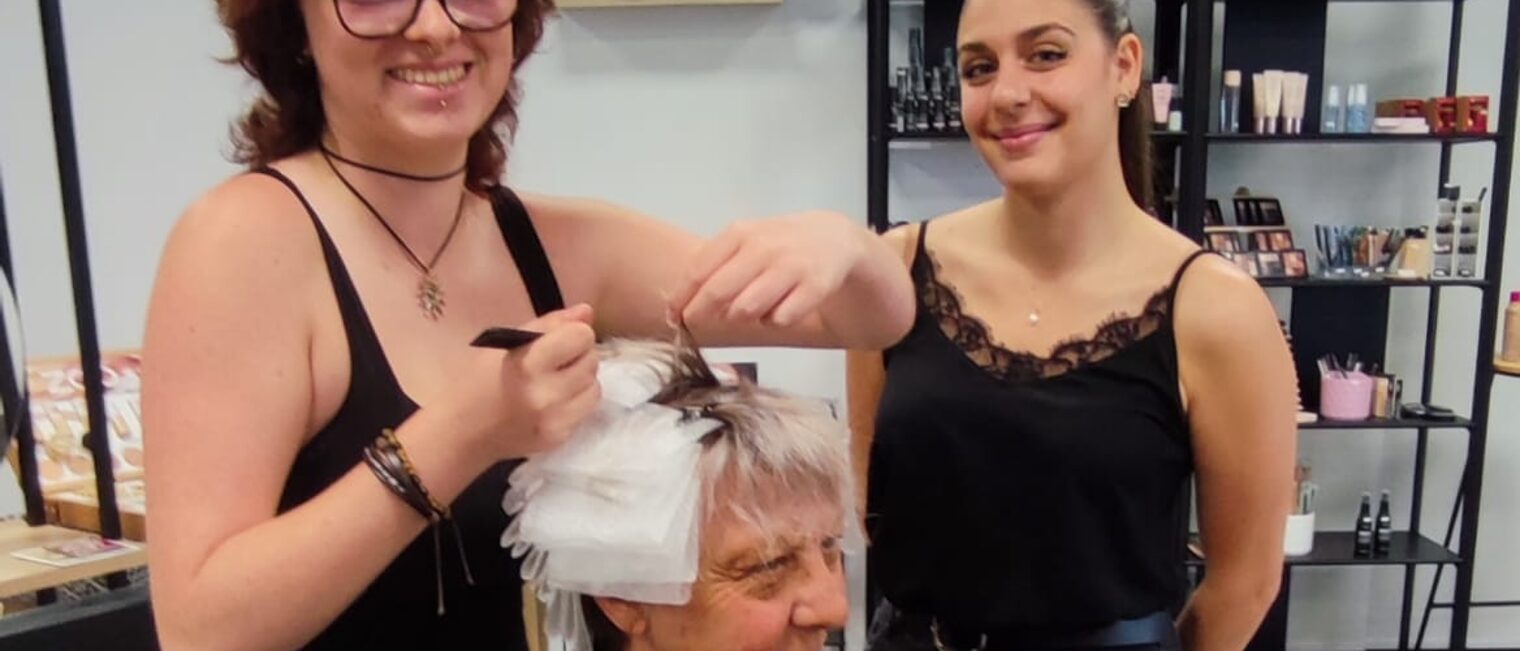 Eine deutsche Azubine frisiert zusammen mit einer Ausbilderin einer Kundin in einem Friseursalon in Lezignan die Haare.