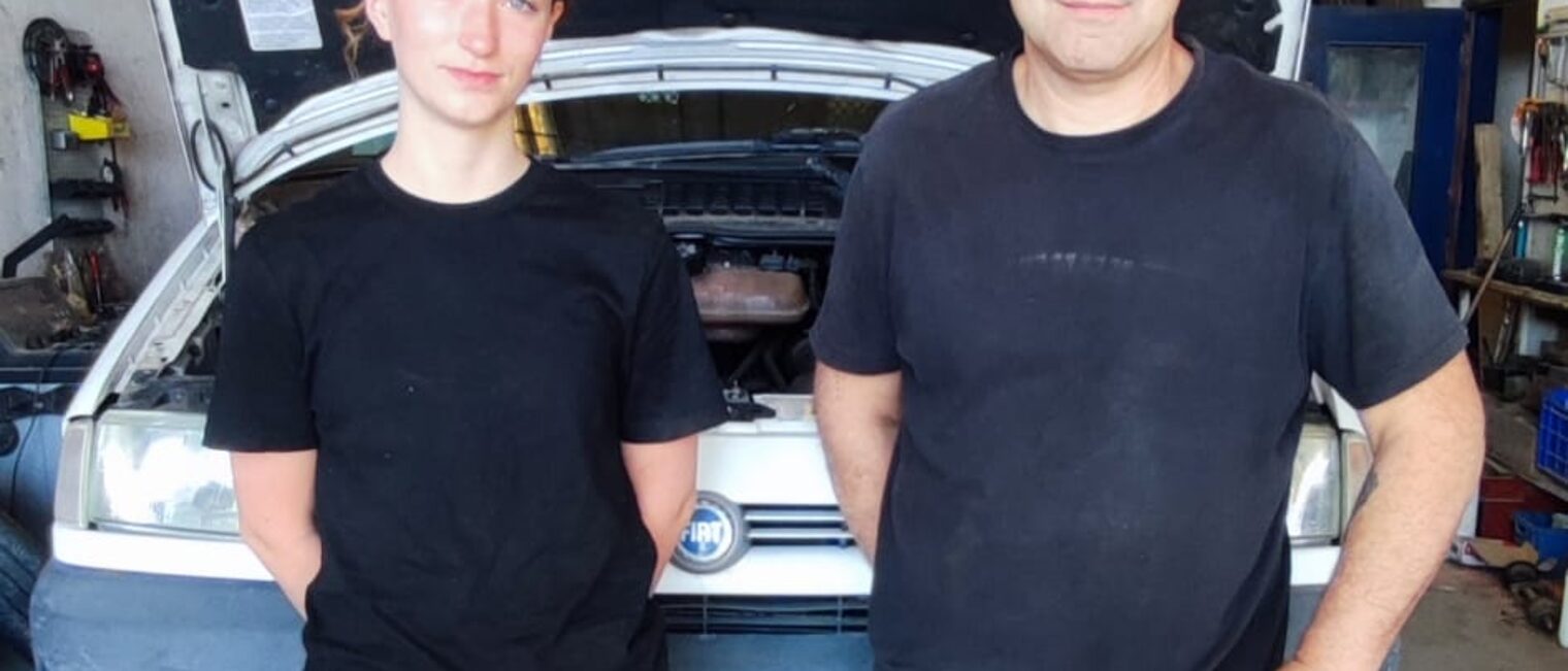Eine deutsche Azubine steht mit einem Ausbilder in einer Autowerkstatt in Lezignan.