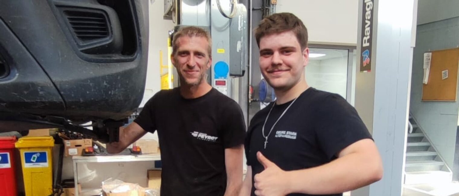 Ein deutscher Azubi steht mit einem Ausbilder in einer Autowerkstatt in Lezignan.