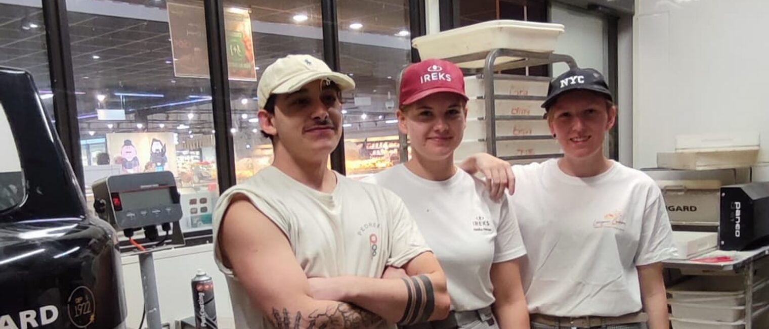 Deutsche Azubis stehen mit einem Ausbilder neben einem Teigmischgerät in einer Bäckerei in Lezignan.