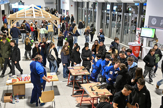 Luftaufnahme der Stände der Betriebe mit den Schülerinnen und Schülern im Foyer der Brose-Arena.