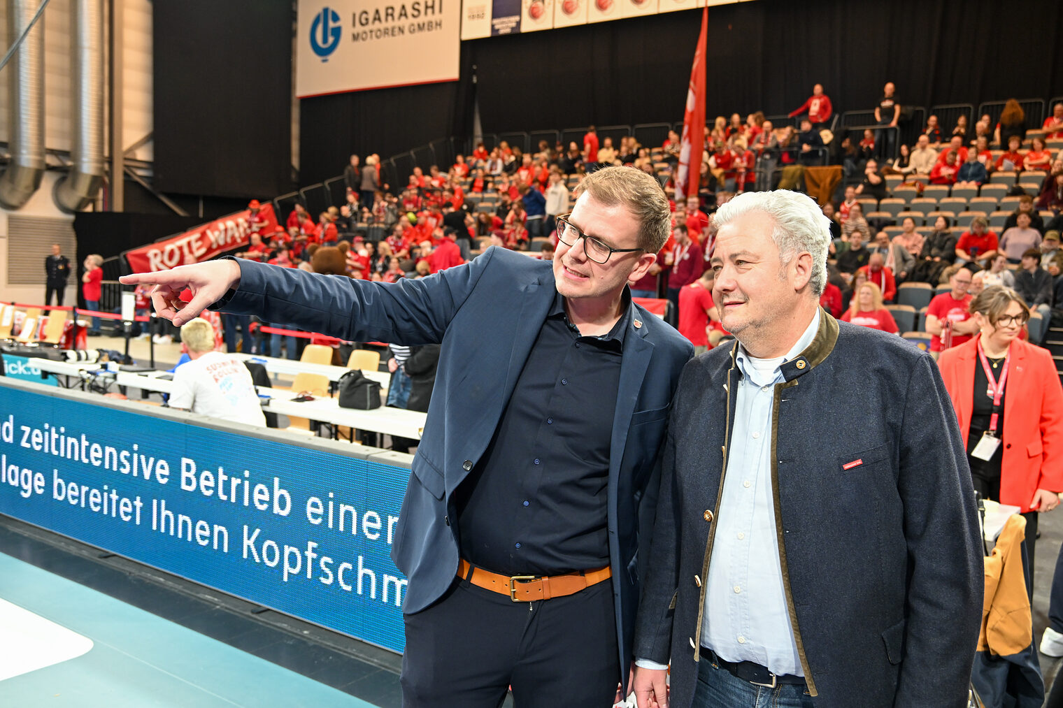 David Silasi erklärt HWK-Geschäftsführer Matthias Graßmann etwas am Spielfeldrand. 