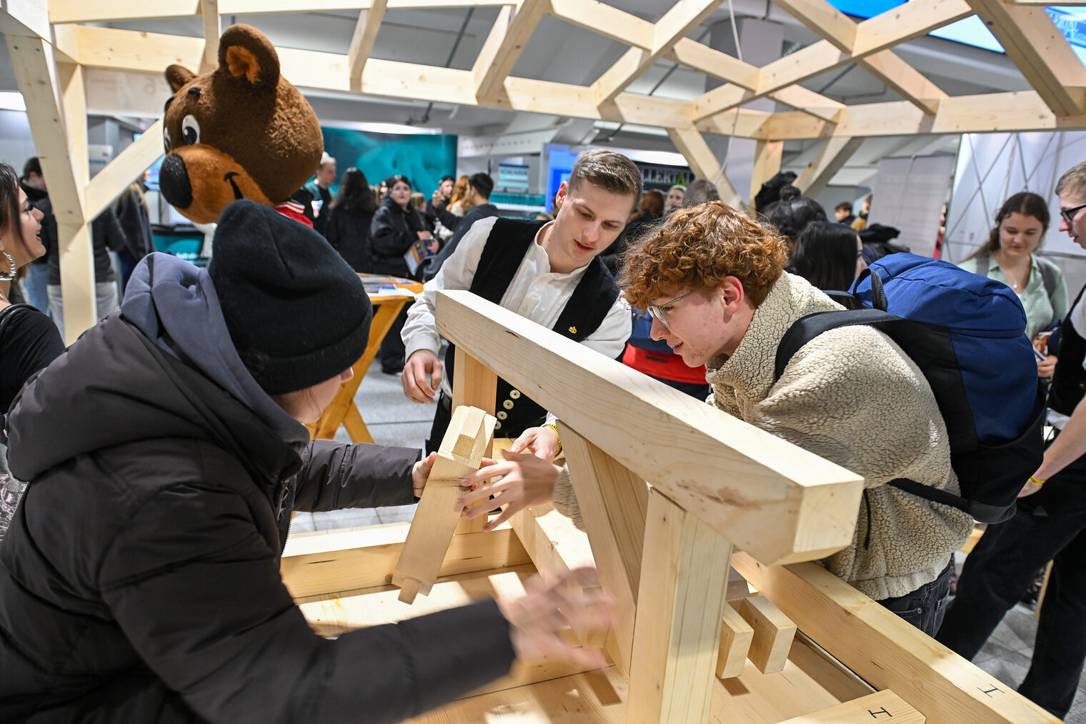 Ein Schüler fügt eine Holzverbindung unter Aufsicht zusammen.
