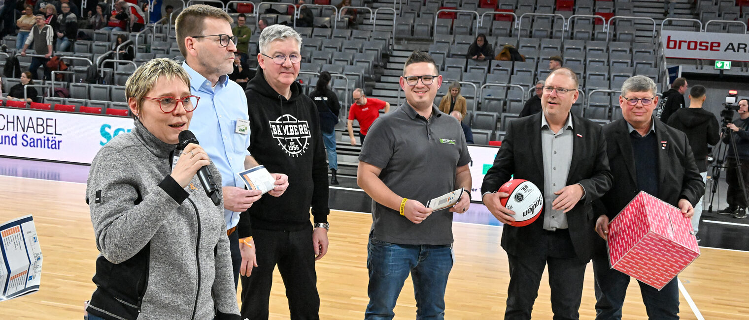 Die HWK-Verantwortlichen stehen auf dem Spielfeld und tragen die Losbox.