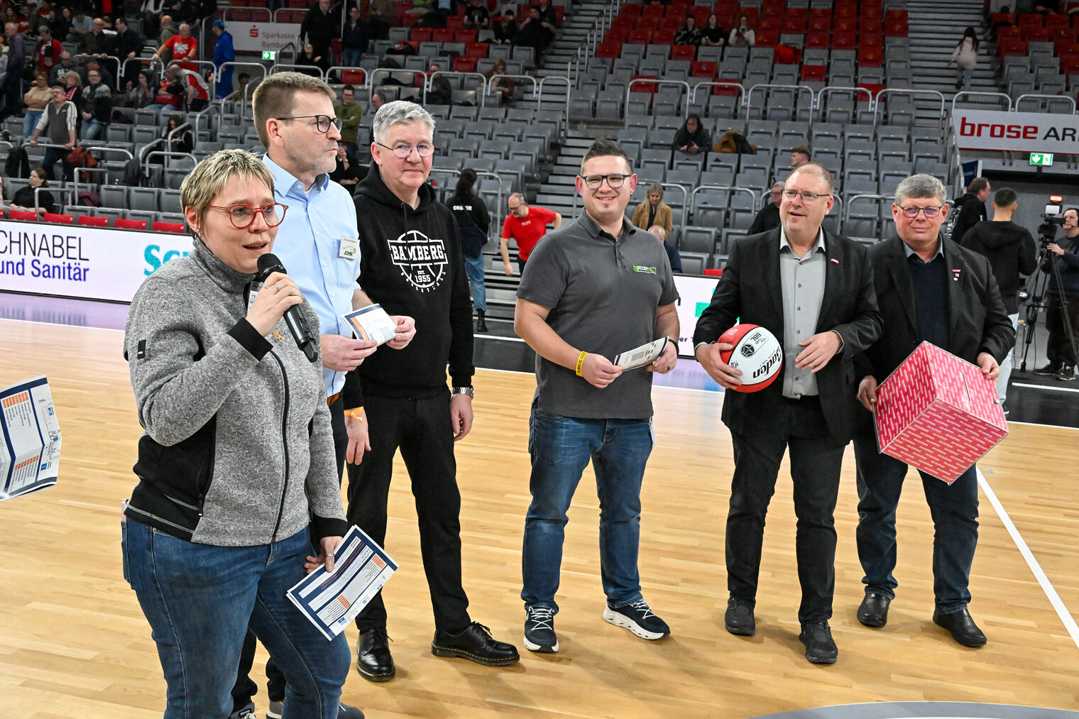 Die HWK-Verantwortlichen stehen auf dem Spielfeld und tragen die Losbox.