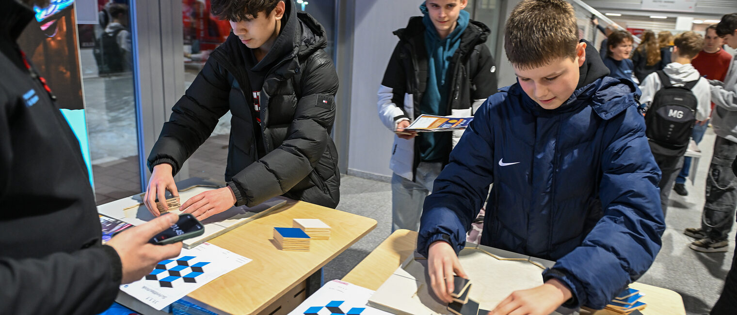 Zwei Schüler versuchen sich an der Fliesenlegechallenge der Handwerkskammer.
