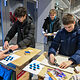 Zwei Schüler versuchen sich an der Fliesenlegechallenge der Handwerkskammer.