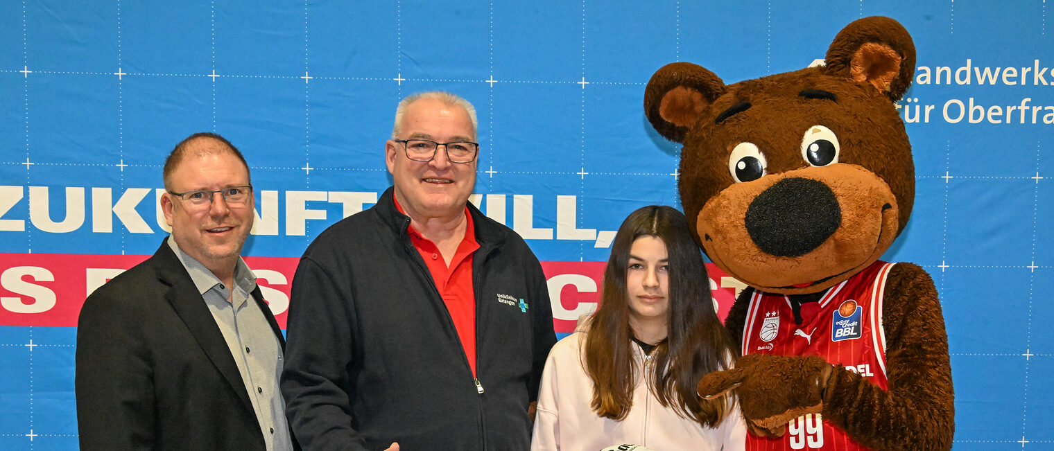 HWK-Vorstand Jens Beland, ein Vertreter des Uniklinikums Erlangen, eine Schülerin mit dem Gewinnerball und Maskottchen Freaky