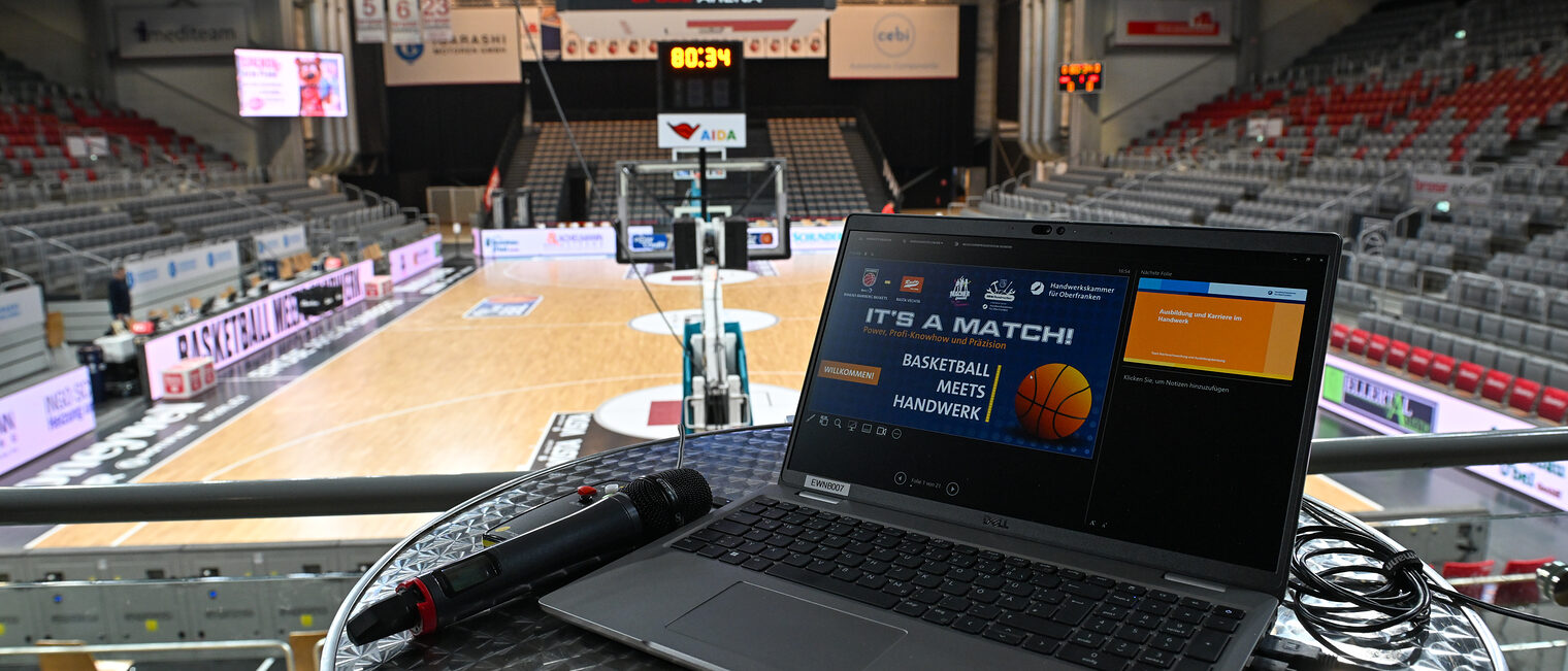 Ein Computer mit der Präsentation der HWK steht in der Halle der Baskets Bamberg.