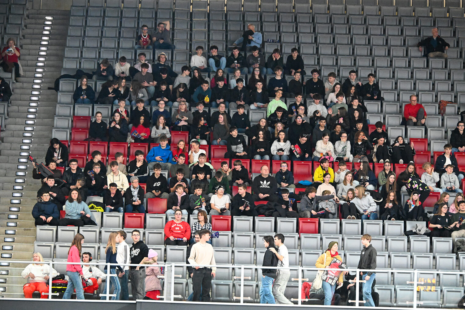 Die Schülerinnen und Schüler sitzen auf der Nordtribüne und sehen sich das Spiel an.