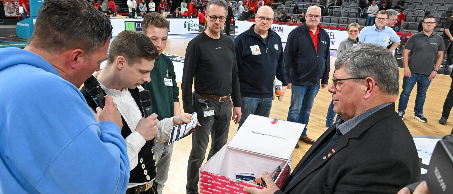 Die Vertreter der Betriebe ziehen die Gewinner aus der Losbox auf dem Spielfeld.