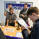 Ein Schüler füllt einen Zettel mit einem Quiz am Stand von Kachelmann Bad und Heizung aus.