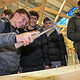 Ein Schüler schlägt einen Nagel mit dem Hammer in einen Holzbalken.