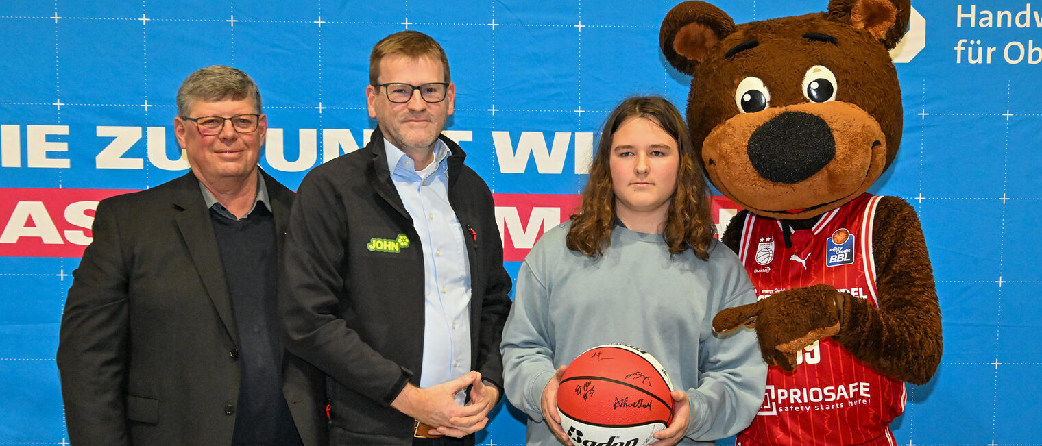 HWK-Vorstandsmitglied Michael Klein, ein Vertreter von John GmbH, ein Schüler mit dem Gewinnerball und Maskottchen Freaky