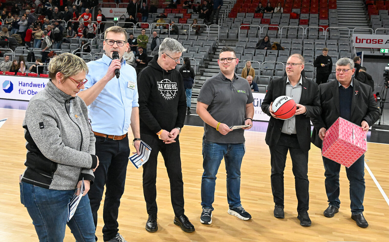 Die Verteter der Betriebe und der HWK nehmen die Verlosung mit der Losbox auf dem Spielfeld vor.