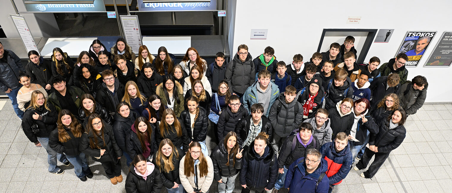 Eine Schulklasse posiert für ein Gruppenfoto in der Brose-Arena.