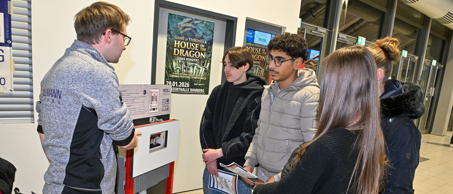 Schülerinnen und Schüler sehen sich eine Heizungsanlage an einem SHK-Stand an. 