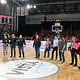 Die Vertreter der Betriebe stehen im Halbkreis auf dem Spielfeld der Brose-Arena.