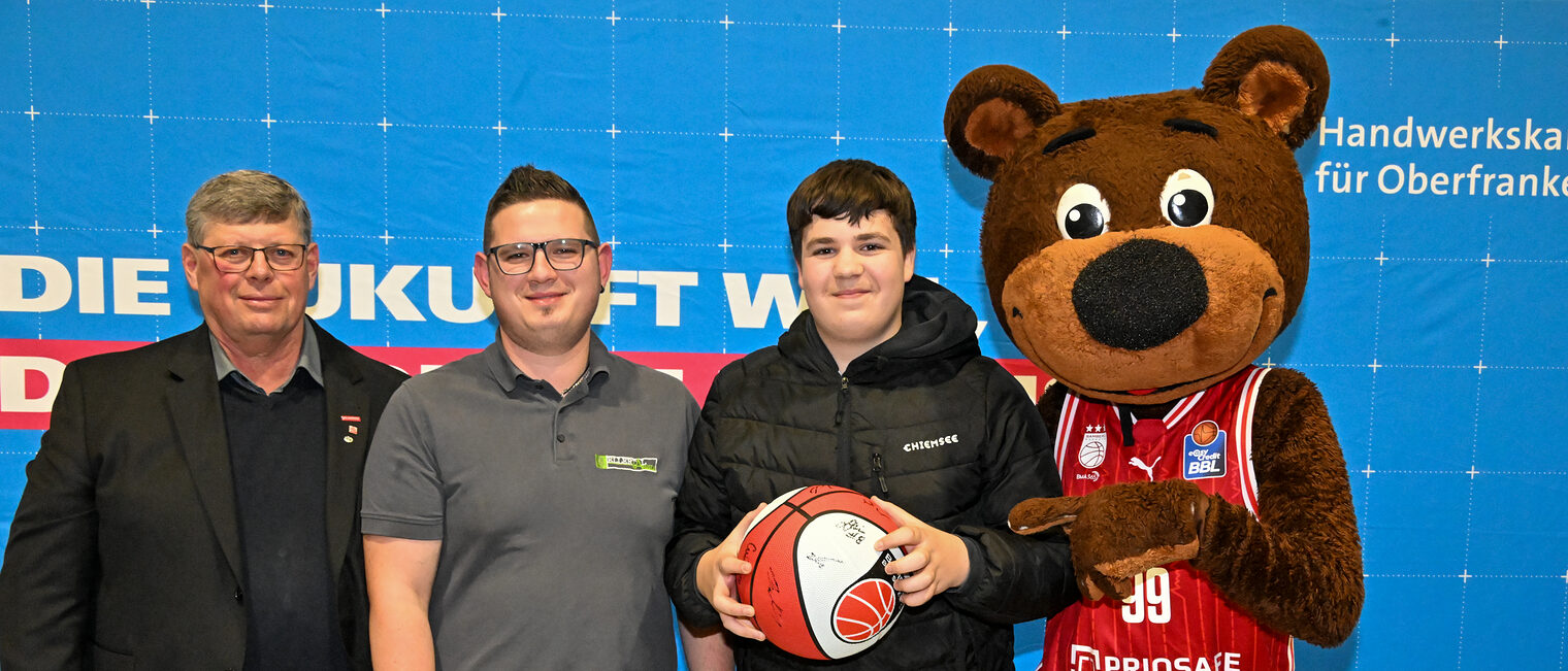 HWK-Vorstandsmitglied Michael Klein, ein Vertreter von Ellertal Akustik, ein Schüler und Maskottchen Freaky