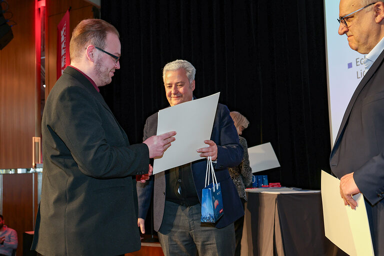 Kammersieger Kevin Reinhardt nimmt seine Urkunde von HWK-Präsident Graßmann entgegen.