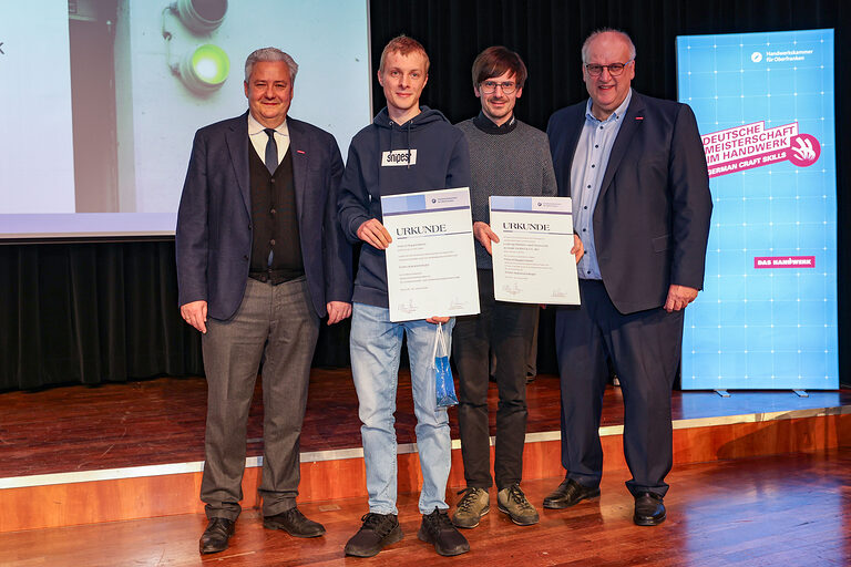 HWK-Präsident Matthias Graßmann, Kammersieger Pascal Ruppenstein, ein Vertreter des Betriebes, und HWK-Hauptgeschäftsführer Reinhard Bauer