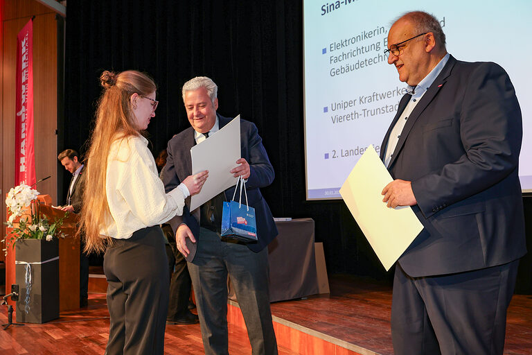 Kammersiegerin Sina-Marie Hartmann nimmt ihre Urkunde von HWK-Präsident Matthias Graßmann entgegen.