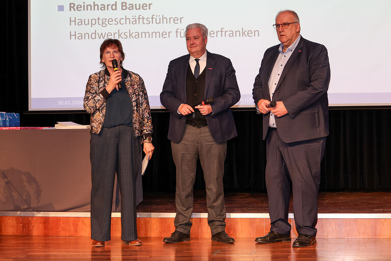 Moderatorin Michaela Heimpel spricht neben HWK-Präsident Matthias Graßmann und HWK-Hauptgeschäftsführer Reinhard Bauer in ein Mikrofon.