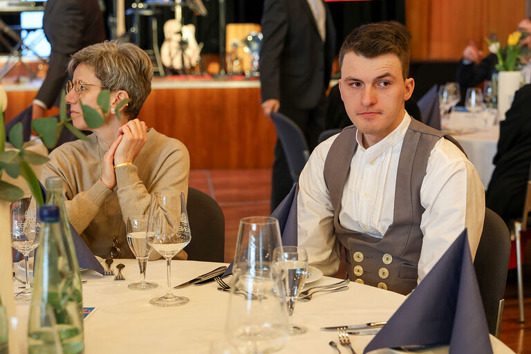 Kammersieger Jakob Distler sitzt mit seiner Familie an einem Tisch. 