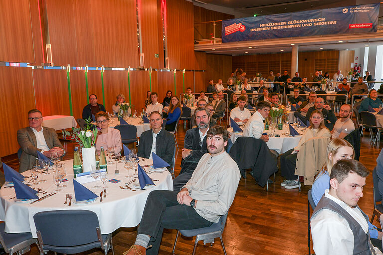 Gäste der Kammersiegerfeier sitzen an Tischen zusammen.