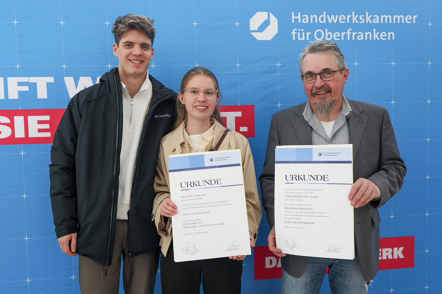 Sina-Marie Hartmann posiert mit ihrer Urkunde und Vertretern ihres Betriebes.