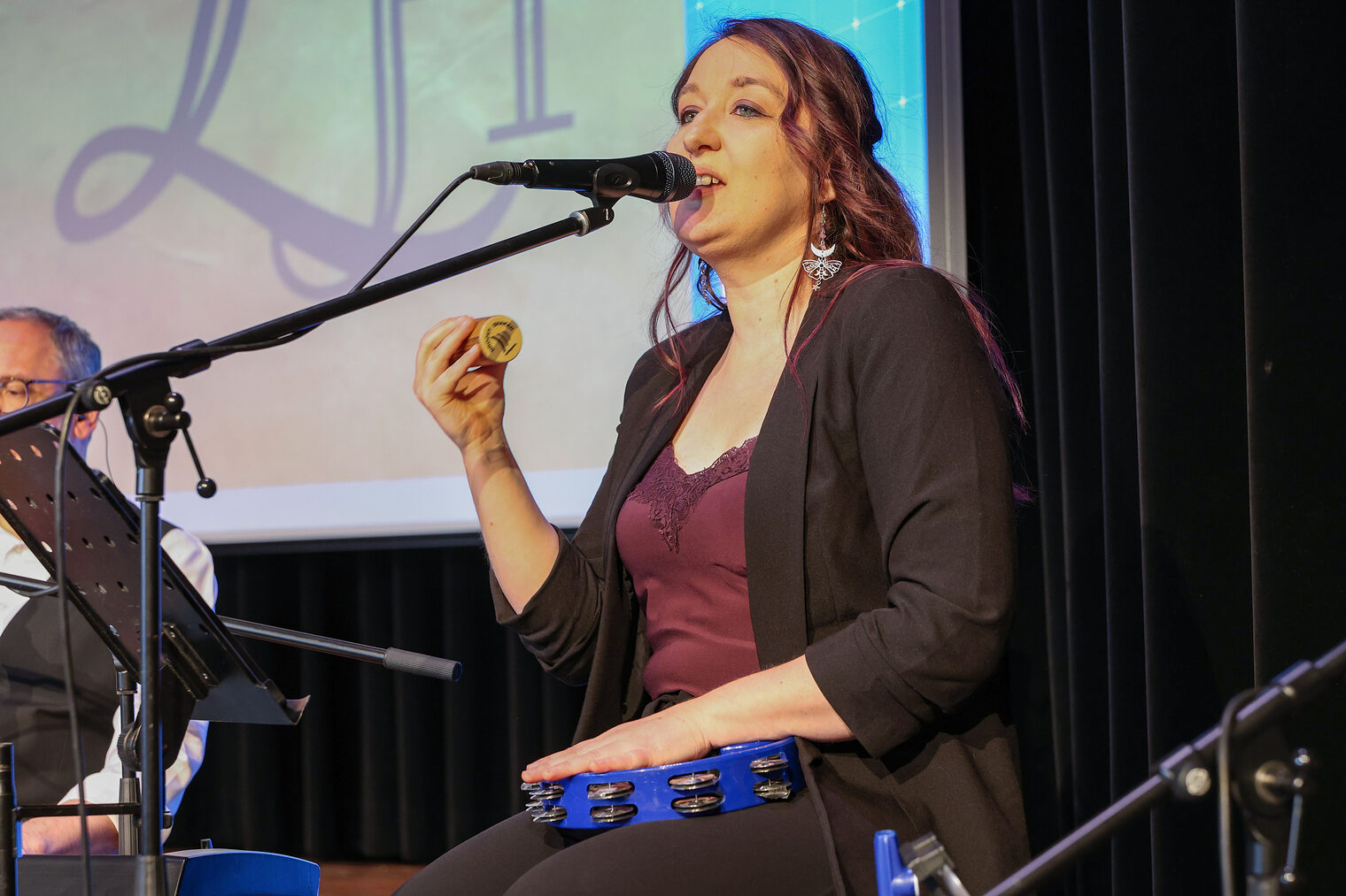 Sängerin Liz singt in ein Mikrofon.