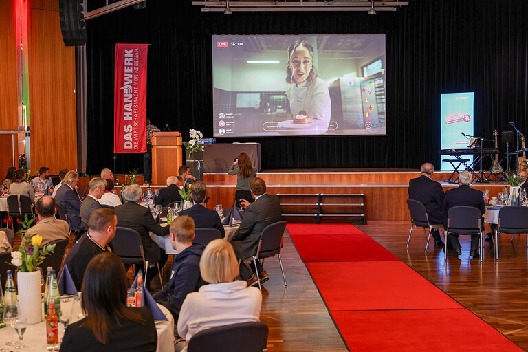 Die Gäste der Kammersiegerfeier sehen sich ein Video auf der Bühne an.