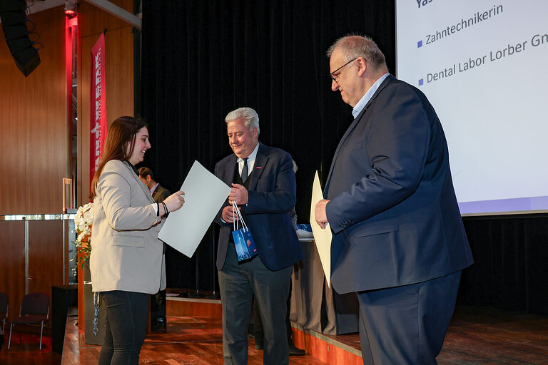 Kammersiegerin Yasemin Strömsdörfer nimmt ihre Urkunde von HWK-Präsident Matthias Graßmann entgegen.