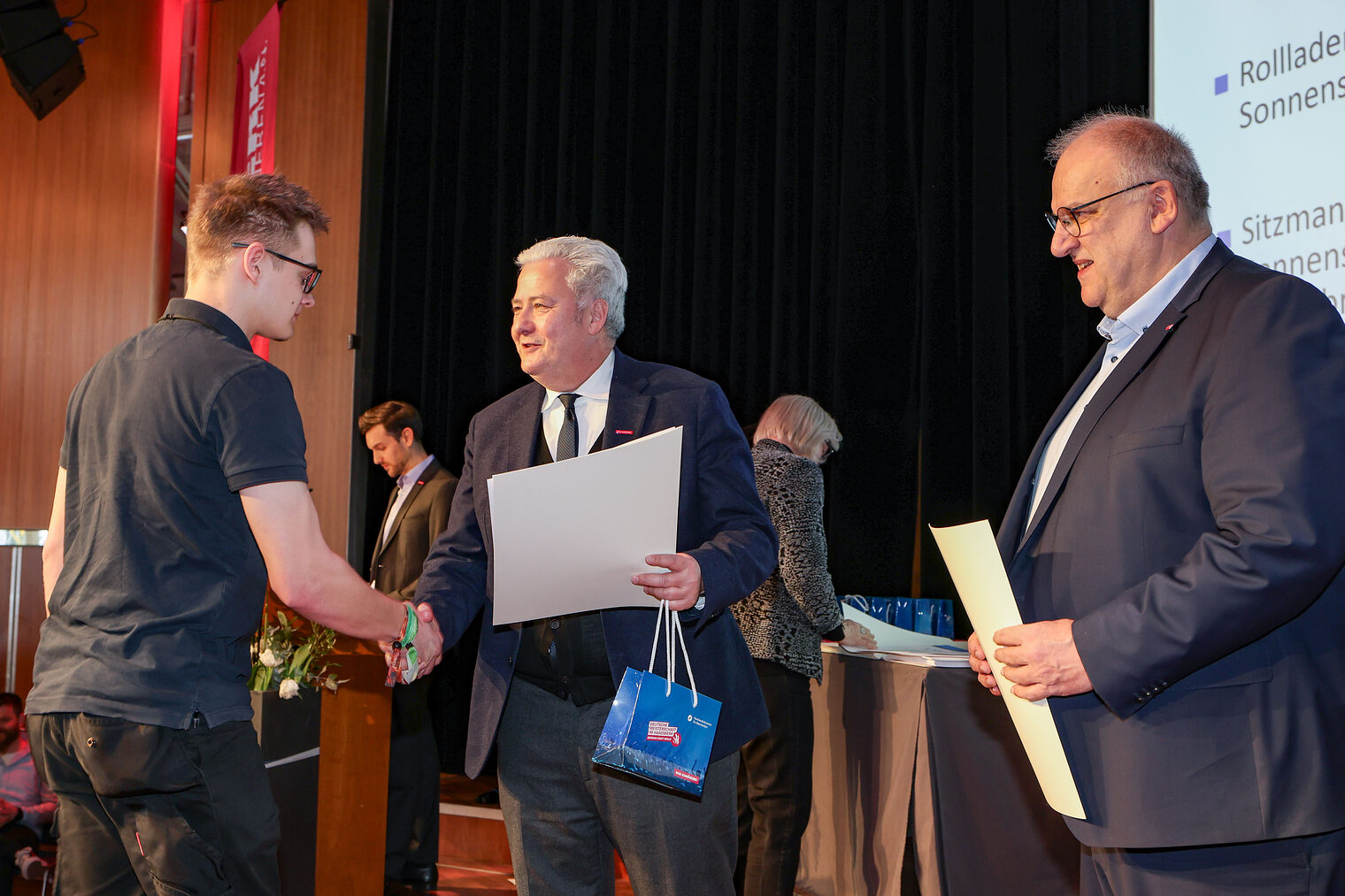 Kammersieger Felix Sitzmann nimmt seine Urkunde von HWK-Präsident Matthias Graßmann entgegen.