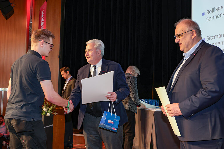 Kammersieger Felix Sitzmann nimmt seine Urkunde von HWK-Präsident Matthias Graßmann entgegen.