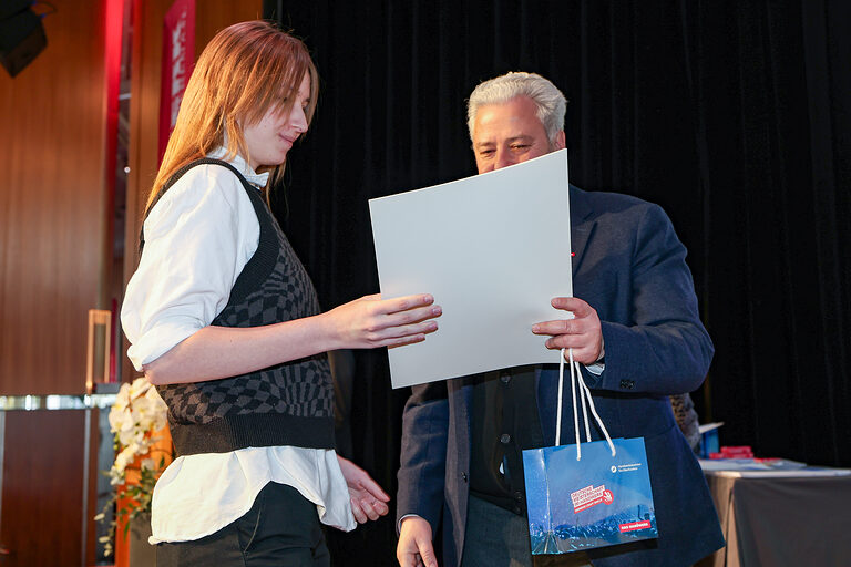 Kammersiegerin Lisa Büttner nimmt ihre Urkunde von HWK-Präsident Matthias Graßmann entgegen.