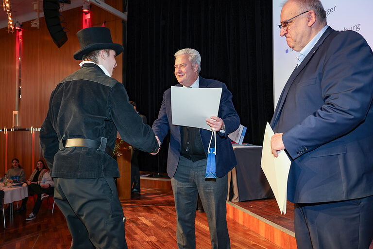 Kammersieger Tom Schreiber nimmt seine Urkunde von HWK-Präsident Matthias Graßmann entgegen.