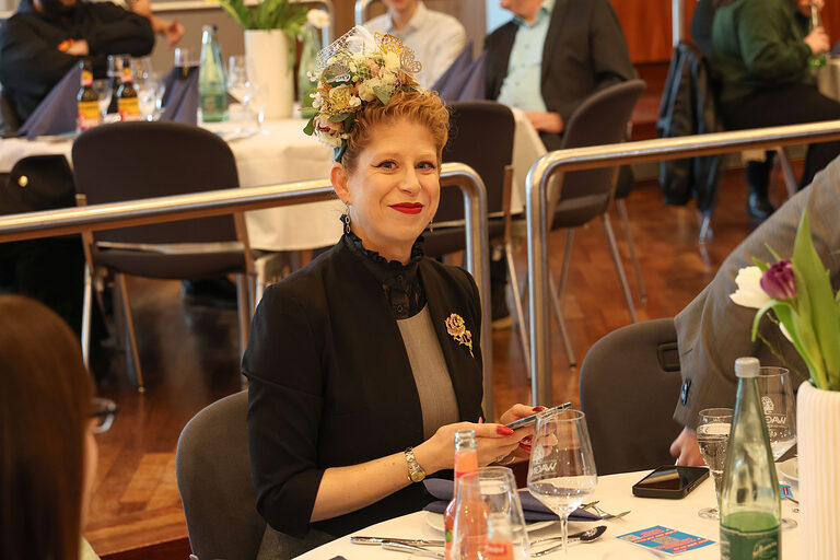 Eine Besucherin der Kammersiegerfeier sitzt an einem Tisch.