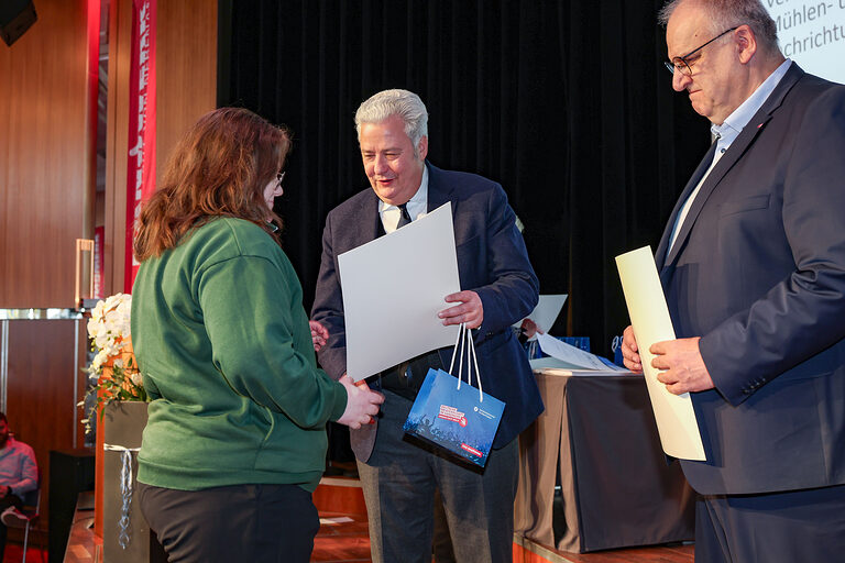 Kammersiegerin Tabea Drescher nimmt ihre Urkunde von HWK-Präsident Matthias Graßmann entgegen.