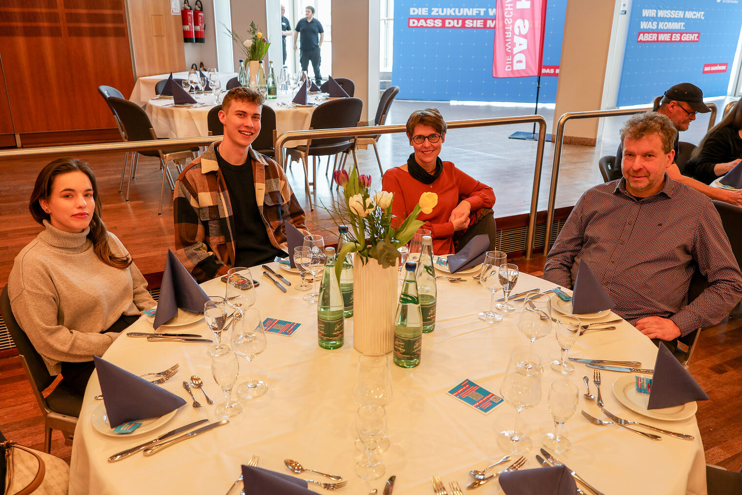Kammersieger und ihre Familien und Begleiter sitzen an einem Tisch.