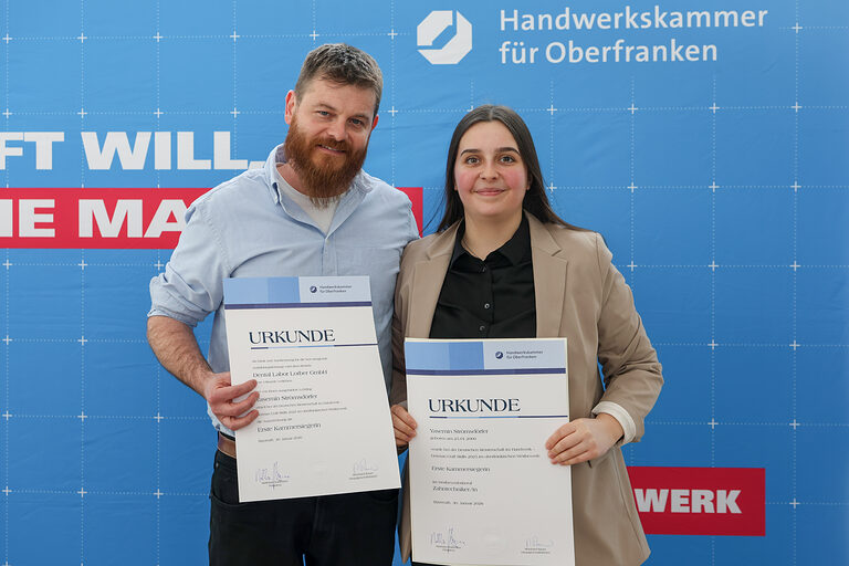 Yasemin Strömsdörfer mit ihrer Kammersiegerurkunde mit einem Vertreter ihres Betriebes Dental Labor Lorber GmbH 