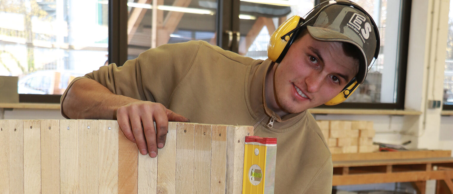 Jakob Distler misst mit einer Wasserwaage etwas ab.