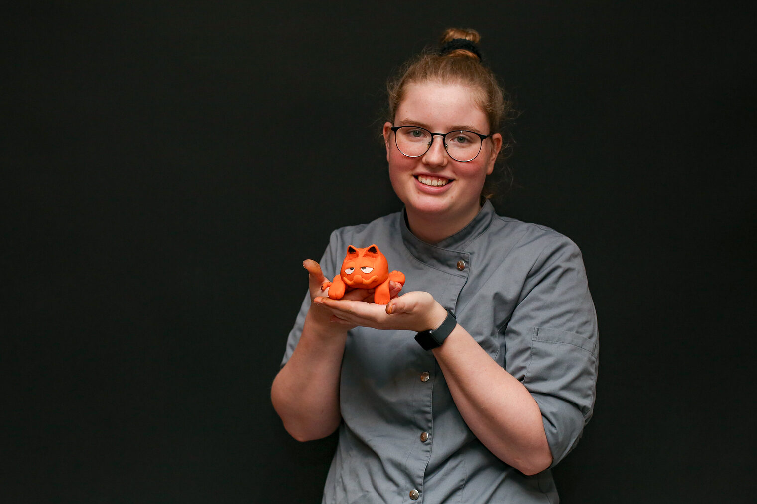 Eine Meisterschülerin präsentiert eine Katzenfigur aus Marzipanmasse.