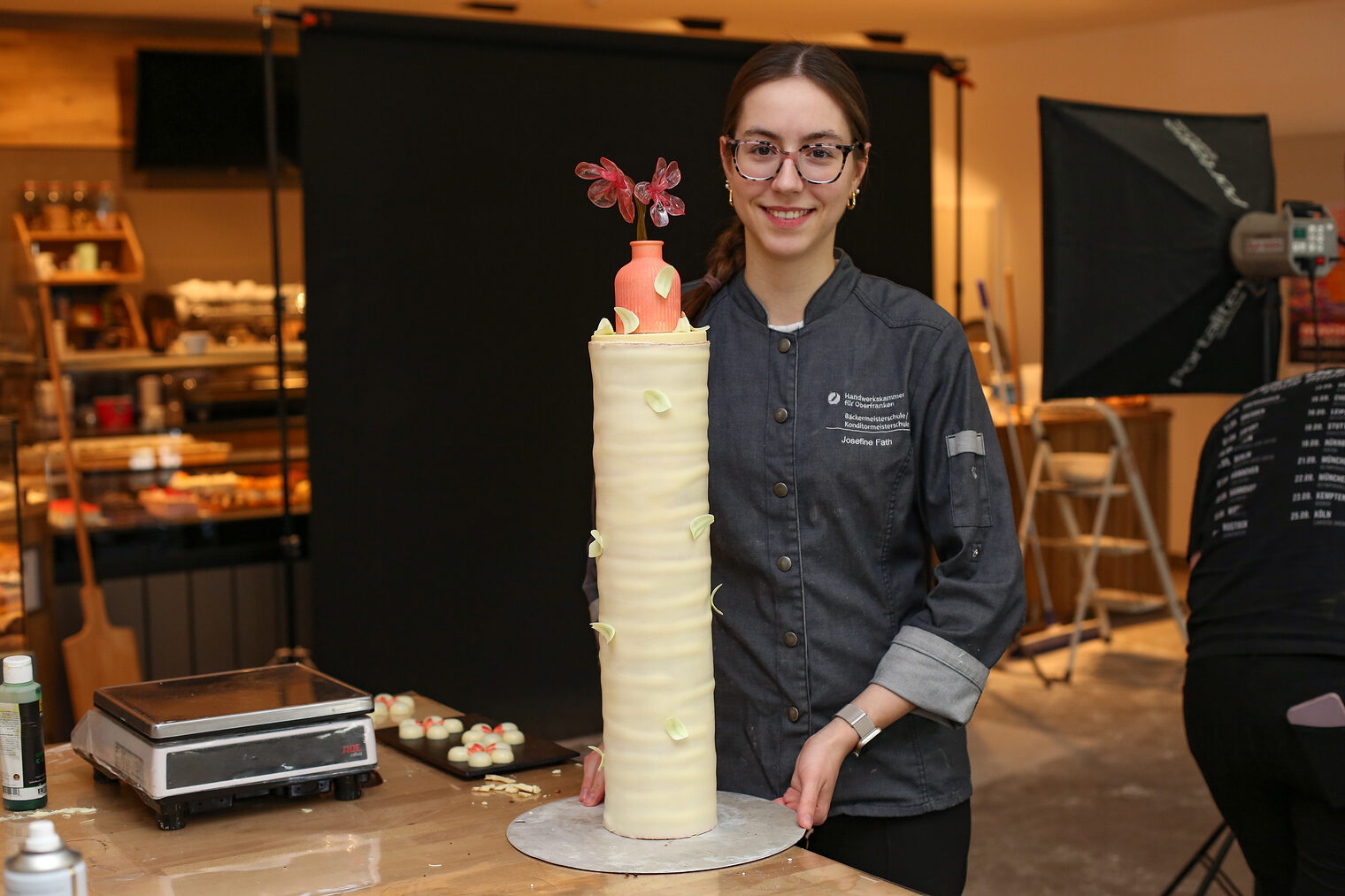 Eine Meisterschülerin präsentiert eine kunstvolle Turmtorte.