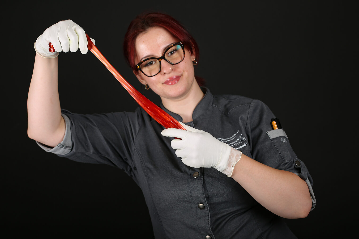 Eine Meisterschülerin hält Zuckerguss in den Händen.