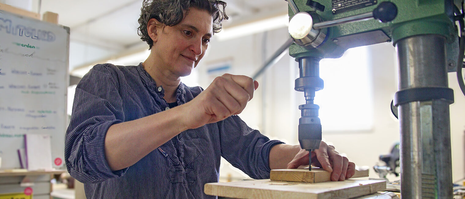 Schreinerin Bianca Krauss bedient eine Ständerbohrmaschine.
