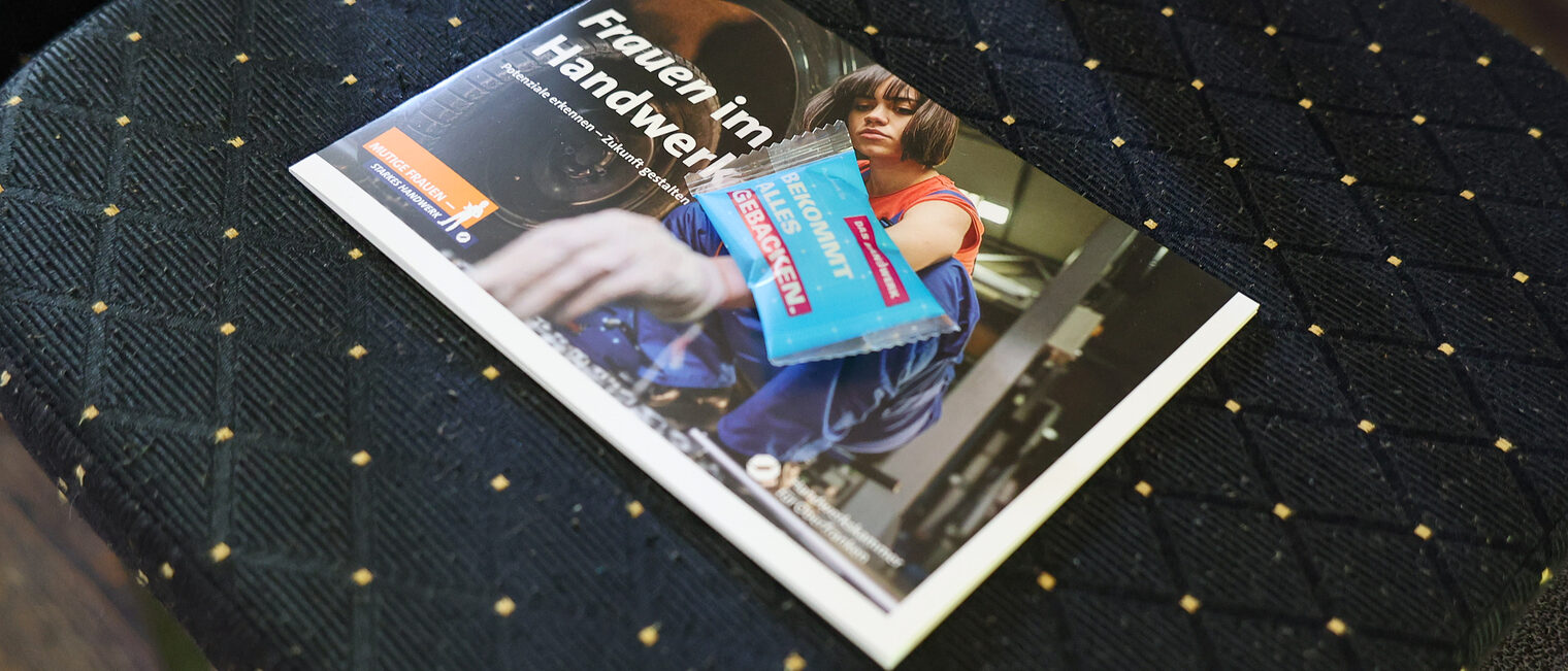 Die Broschüre zu Frauen im Handwerk liegt auf einem Stuhl. 